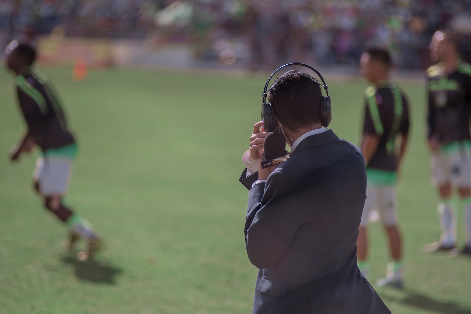 selective focus photography of man using headphones near athletes