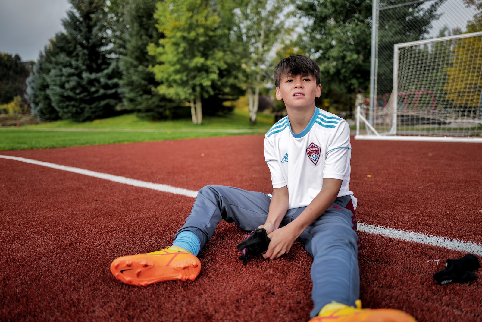 a boy sitting on a baseball field